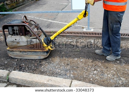 road construction worker with road roller