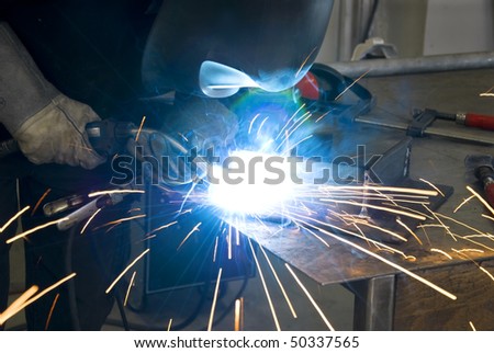 welder with workpiece and a lot of sparks