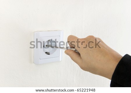 hand of an electrician repairing a socket outlet