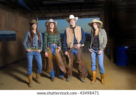 Cowgirls and Cowboy in barn after sunset