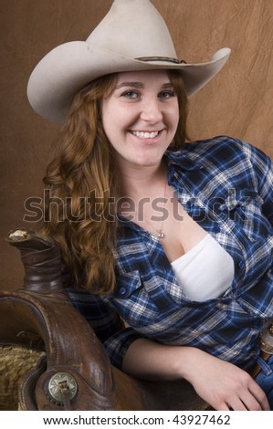 Cowgirl in studio with hat, jeans, and chaps