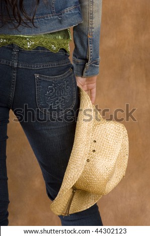 Cowgirl wearing green top with jean jacket and straw hat