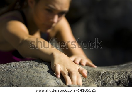 Teenage girl free rock climbing in summer