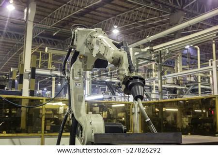 Robot welding in teaching mode in car factory.