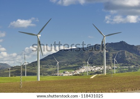 Collection of wind turbines producing clean alternative energy in remote location in  white village (pueblo blanco) Andalusia, Spain
