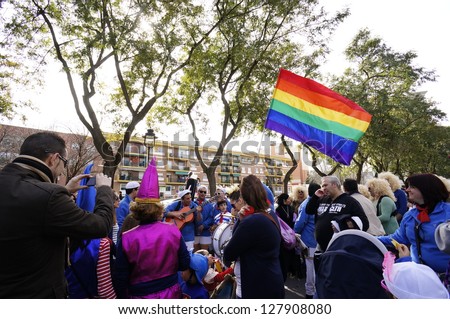 HUELVA, ANDALUSIA, SPAIN - FEBRUARY 10: The Carnival parade of Huelva, rainbow flag, procession with people in traditional street, on February 10, 2013 in Huelva, Andalusia, Spain