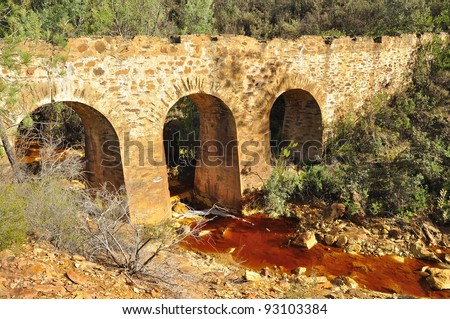 Old bridge and the red river in southwestern Spain Andalusia. Abandoned historical old bridge