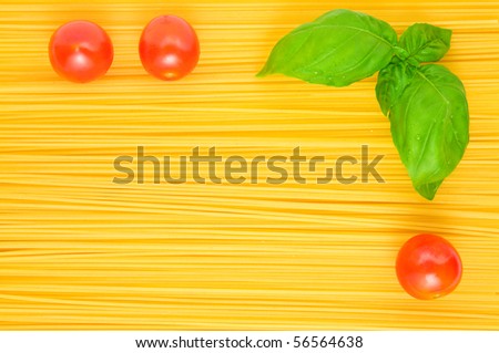 Frame of Spaghetti pasta background with basil and tomatoes; Texture effect