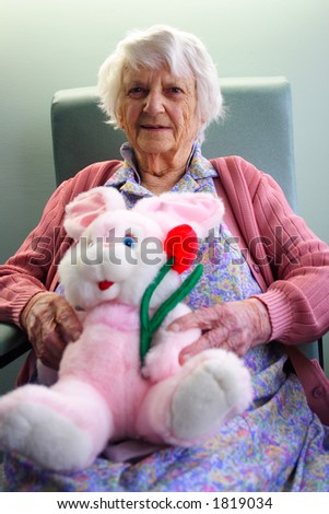 Old woman portrait, 93 years old, holding stuffed easter bunny rabbit
