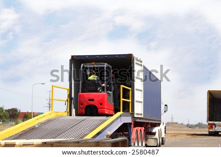Semi truck with forklift driver on loading ramp