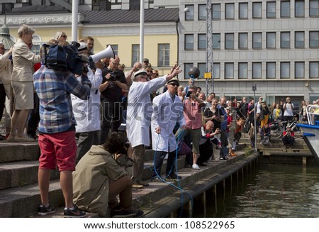 HELSINKI FINLAND-JULY 25:Finnish Unscientific Society throwing Cold Stone on Jaakko\'s Day July 25, 2012 at Cholera Basin in Helsinki,Finland.According to Finnish belief throwing cold stone cools lakes