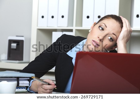 Tired bank clerk with ballpen at her desk
