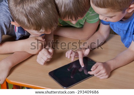 School boys are watching a video on a tablet pc