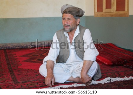 BAHARAK, AFGHANISTAN - JUNE 2: Village elder sits and welcomes guests to the opening of his community center, funded by Afghanaid on June 2 2010 in Baharak, Afghanistan