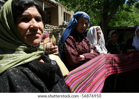 BAHARAK, AFGHANISTAN - JUNE 1: Afghan women show off cloth they have woven on June 1, 2010 in Baharak, Afghanistan. They are members of a co-operative micro enterprise scheme.
