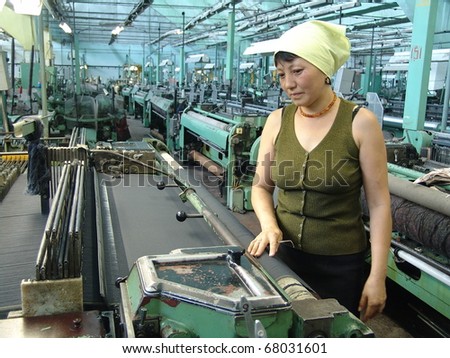 BISHKEK, KYRGYZSTAN - JULY 11: Woman stands alone in the factory where she used to work on July 11, 2010 in Bishkek, Kyrgyzstan. Manufacturing in the country has been hit by the global recession.