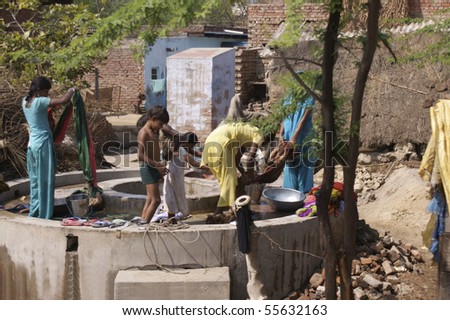 RAJASTHAN, INDIA - FEB. 25: Washing day in an Indian village. Women and children wash cloth by hand in a public well on February 25, 2010 in Rajasthan, India.