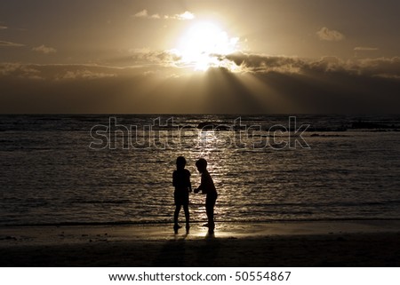 Two children enjoying the sunny South African weather on a beach in the Western Cape province