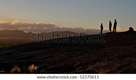 Group of friends standing on a mountain top at dawn