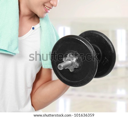 close up of healthy fitness man exercising with dumbbells in the gym