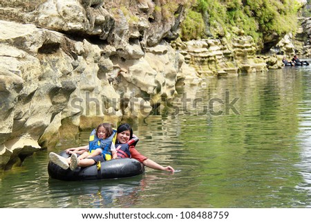 Happy family floating on inflatable tube in river during vacation