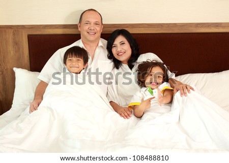 Family lying down in the bedroom