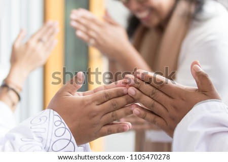 close up of embracing and shake hand each other during eid mubarak celebration. Forgiving