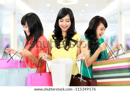 Portrait of happy shopping woman looking inside shopping bags at the mall