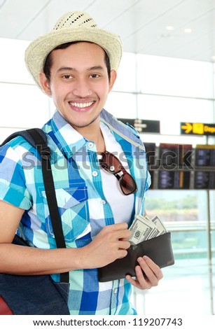 Asian tourist smiling counting money in the airport