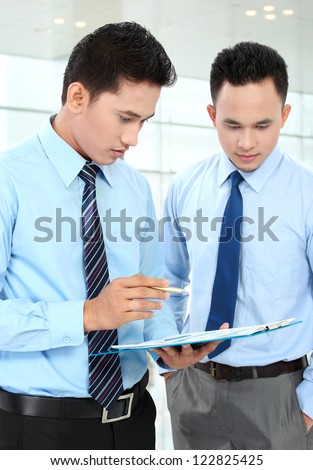 Two businessmen discussing a business chart growth