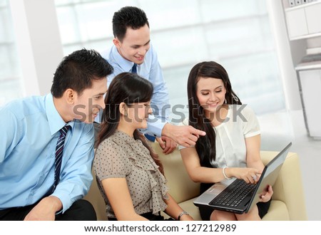 group of happy business people working on laptop during informal meeting