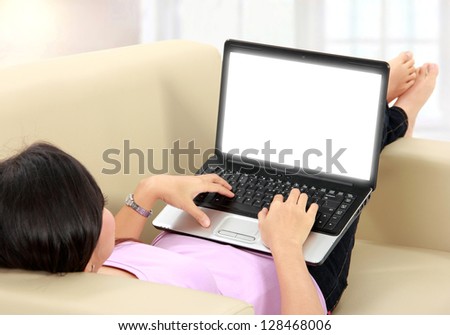 Portrait of beautiful business woman sitting at sofa and using laptop while looking at camera