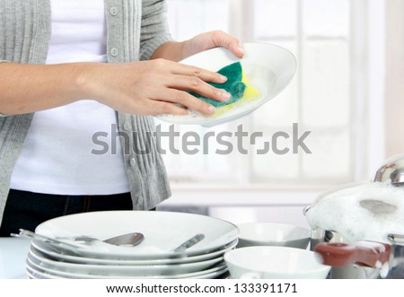 close up hands of Woman Washing Dishes in the kitchen
