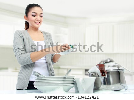 pretty asian woman doing house work, washing dishes
