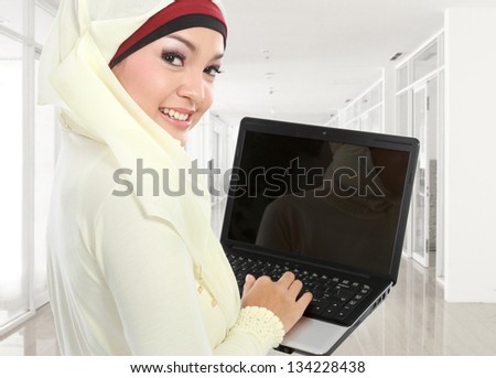 young asian muslim woman in head scarf studying using laptop computer in campus