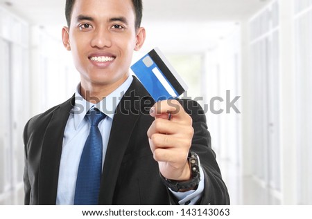 business man holding a credit card and smile on white background