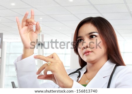 Woman doctor look syringe needle in hospital