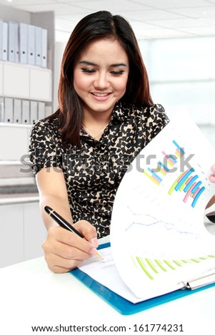 Portrait of young businesswoman working with papers in office