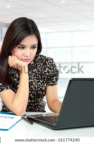 Portrait of busy business woman working with laptop at her office