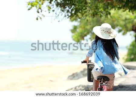 Carefree Woman Having Fun Enjoying Summer Riding Bicycle At The Beach