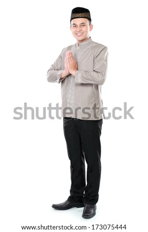 portrait of smiling asian muslim man welcoming you isolated over white background portrait of smiling asian muslim man welcoming you isolated over white background