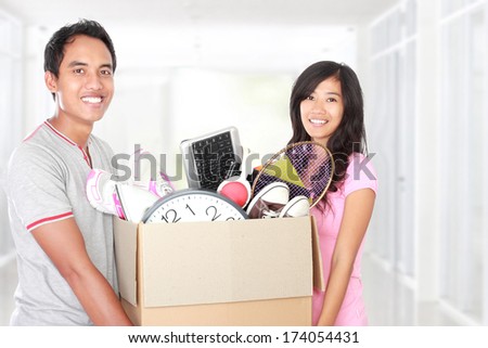 man and woman with their stuff inside the cardboard box ready to move. moving day concept