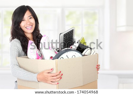 woman with her stuff inside the cardboard box ready to move. moving day concept