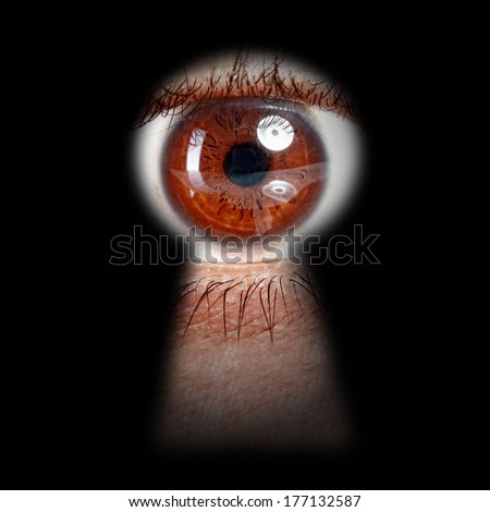 eye peeking through a keyhole concept for curiosity, stalker, surveillance and security