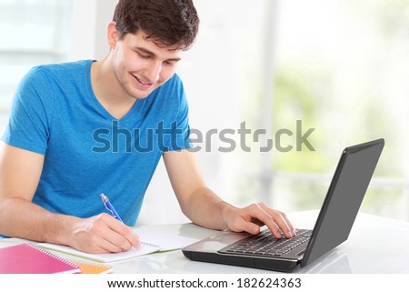 handsome young student happy about research results from the internet