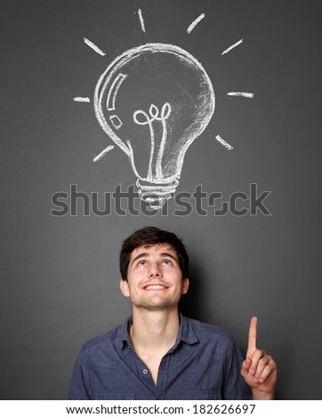 portrait of handsome young man with lightbulb icon on top of him idea concept portrait of handsome young man with lightbulb icon on top of him idea concept