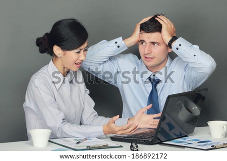sad and depressed businessman and woman sitting at table during meeting