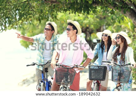 carefree group friends having fun and smiling riding bicycle during the summer day