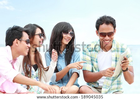 portrait of Group Friends Enjoying Beach Holiday together with tablet pc. technology and internet concept