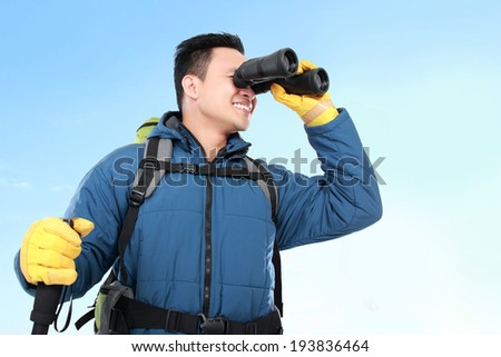 Hiker man tourist looking around with binoculars. Hiking